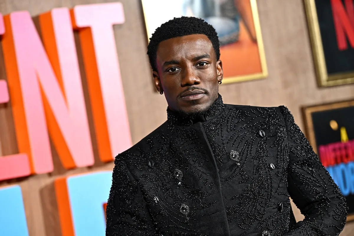 Chibuikem Uche, oblečený v čiernom, pózuje na fotke na premiére filmu Iný svet